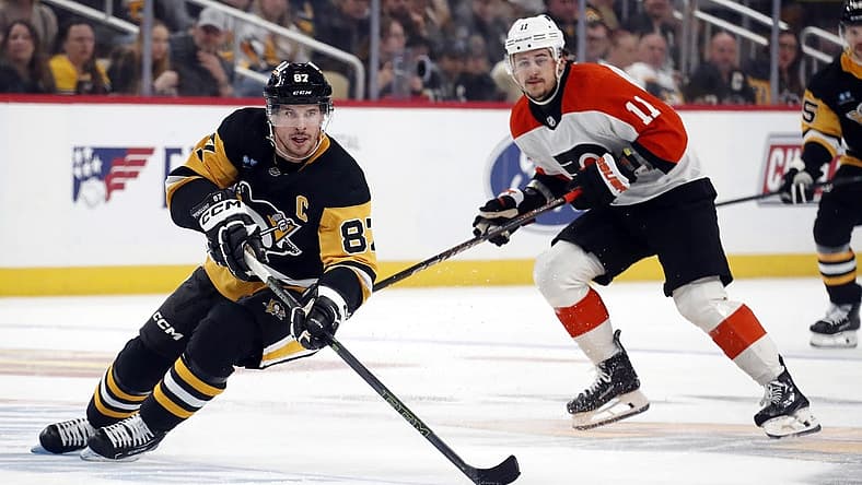 Dec 2, 2023; Pittsburgh, Pennsylvania, USA; Pittsburgh Penguins center Sidney Crosby (87) skates up ice with the puck ahead of Philadelphia Flyers right wing Travis Konecny (11) during the third period at PPG Paints Arena. The Flyers won 4-3 in a shootout. Mandatory Credit: Charles LeClaire-USA TODAY Sports