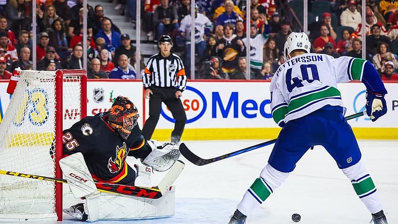 Dec 2, 2023; Calgary, Alberta, CAN; Calgary Flames goaltender Jacob Markstrom (25) guards his net against Vancouver Canucks center Elias Pettersson (40) during the first period at Scotiabank Saddledome. Mandatory Credit: Sergei Belski-USA TODAY Sports