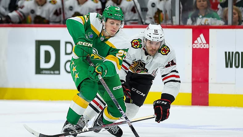 Dec 3, 2023; Saint Paul, Minnesota, USA; Minnesota Wild center Marco Rossi (23) and Chicago Blackhawks right wing Taylor Raddysh (11) compete for the puck during the second period at Xcel Energy Center. Mandatory Credit: Matt Krohn-USA TODAY Sports