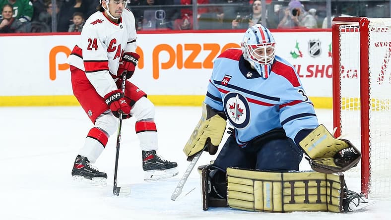 Dec 4, 2023; Winnipeg, Manitoba, CAN; Winnipeg Jets goalie Laurent Boissoit (39) makes a save as Carolina Hurricanes forward Seth Jarvis (24) looks for a rebound during the first period at Canada Life Centre. Mandatory Credit: Terrence Lee-USA TODAY Sports