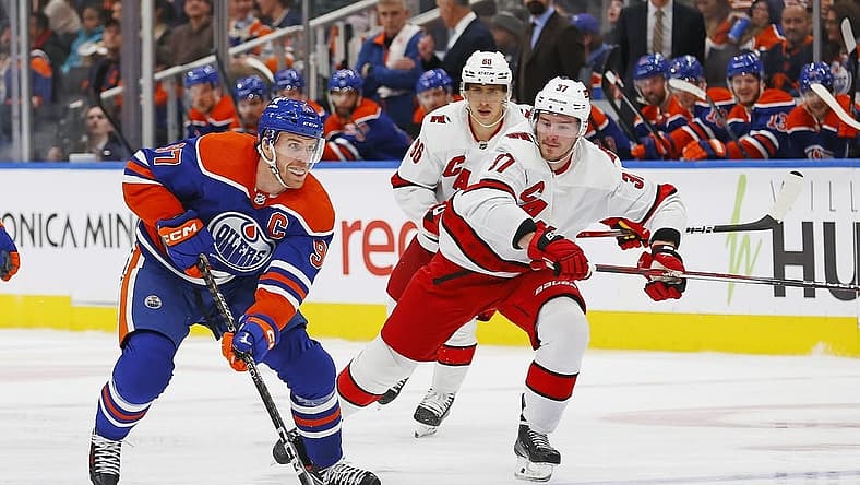 Dec 6, 2023; Edmonton, Alberta, CAN; Edmonton Oilers forward Connor McDavid (97) looks to make a pass in front of Carolina Hurricanes forward Andrei Svechnikov (37) during the third period at Rogers Place. Mandatory Credit: Perry Nelson-USA TODAY Sports