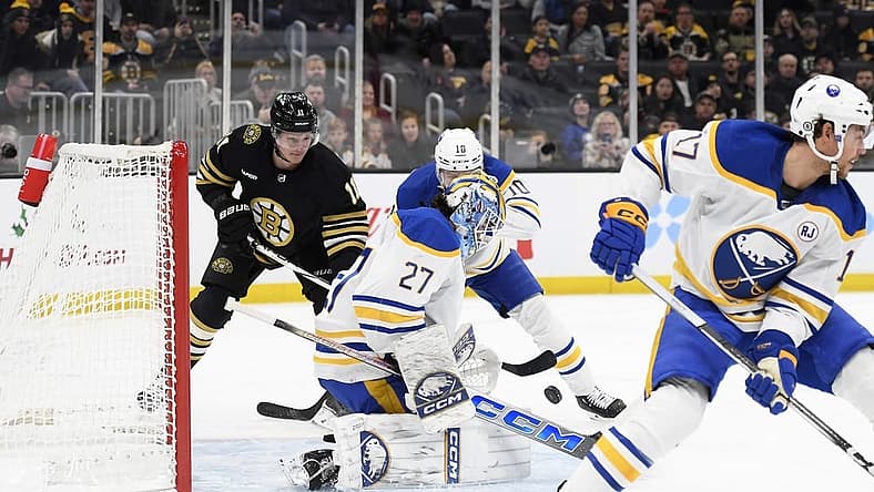 Dec 7, 2023; Boston, Massachusetts, USA; Buffalo Sabres goaltender Devon Levi (27) makes a save in front of Boston Bruins center Trent Frederic (11) and defenseman Henri Jokiharju (10) during the first period at TD Garden. Mandatory Credit: Bob DeChiara-USA TODAY Sports
