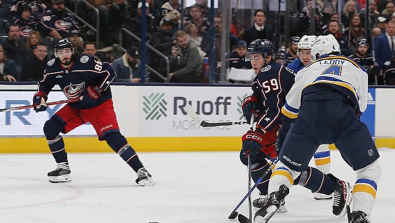Dec 8, 2023; Columbus, Ohio, USA; Columbus Blue Jackets right wing Yegor Chinakhov (59) chips the puck past St. Louis Blues defenseman Nick Leddy (4) during the second period at Nationwide Arena. Mandatory Credit: Russell LaBounty-USA TODAY Sports