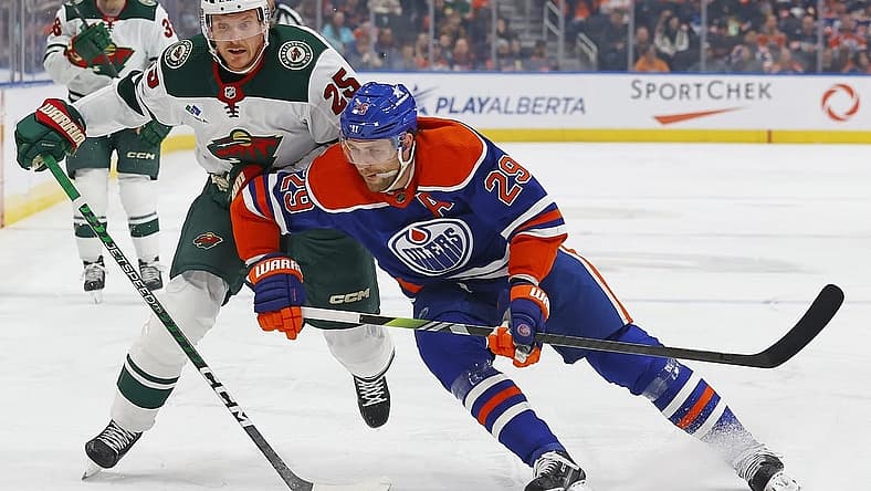 Dec 8, 2023; Edmonton, Alberta, CAN; Minnesota Wild defensemen Jonas Brodin (25) and Edmonton Oilers forward Leon Draisaitl (29) battles for position during the first period at Rogers Place. Mandatory Credit: Perry Nelson-USA TODAY Sports