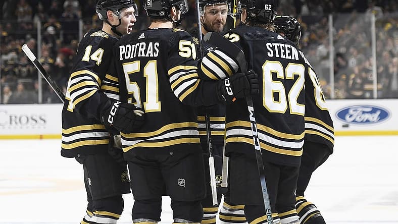 Dec 9, 2023; Boston, Massachusetts, USA;  Boston Bruins defenseman Ian Mitchell (14) center Matthew Poitras (51) center Oskar Steen (62) and defenseman Kevin Shattenkirk (12) celebrate after a goal by right wing David Pastrnak (88) against the Arizona Coyotes during the first period at TD Garden. Mandatory Credit: Bob DeChiara-USA TODAY Sports