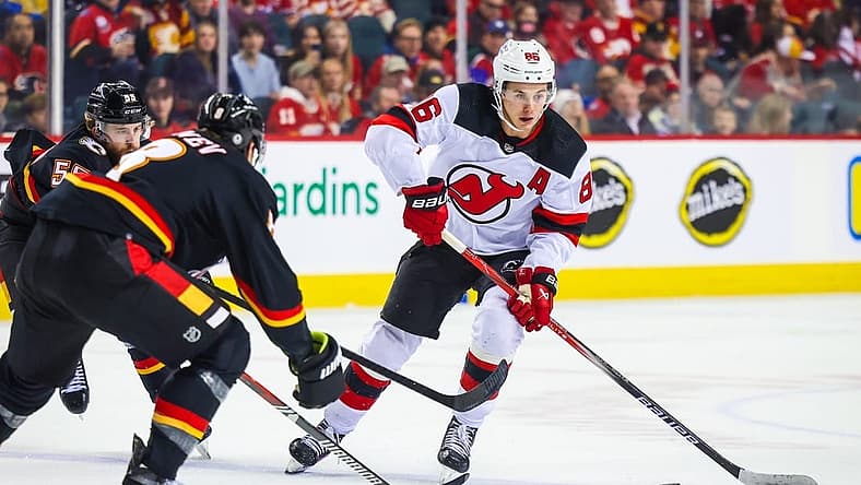 Dec 9, 2023; Calgary, Alberta, CAN; New Jersey Devils center Jack Hughes (86) controls the puck against the Calgary Flames during the first period at Scotiabank Saddledome. Mandatory Credit: Sergei Belski-USA TODAY Sports