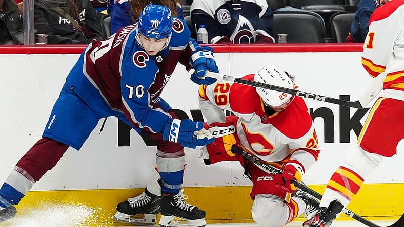 Dec 11, 2023; Denver, Colorado, USA; Colorado Avalanche defenseman Sam Malinski (70) hits Calgary Flames center Dillon Dube (29) in the third period at Ball Arena. Mandatory Credit: Ron Chenoy-USA TODAY Sports