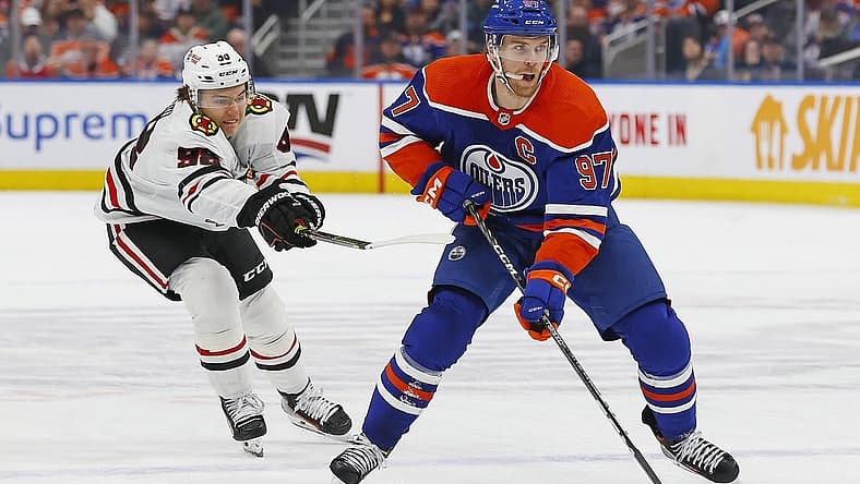 Dec 12, 2023; Edmonton, Alberta, CAN; Chicago Blackhawks forward Connor Bedard (98) tries to knock the puck away from Edmonton Oilers forward Connor McDavid (97) during the first period at Rogers Place. Mandatory Credit: Perry Nelson-USA TODAY Sports