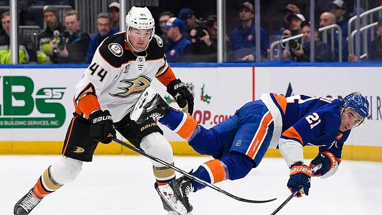 Dec 13, 2023; Elmont, New York, USA; New York Islanders center Kyle Palmieri (21) falls to the ice as Anaheim Ducks left wing Ross Johnston (44) goes after the loose puck during the first period at UBS Arena. Mandatory Credit: Dennis Schneidler-USA TODAY Sports