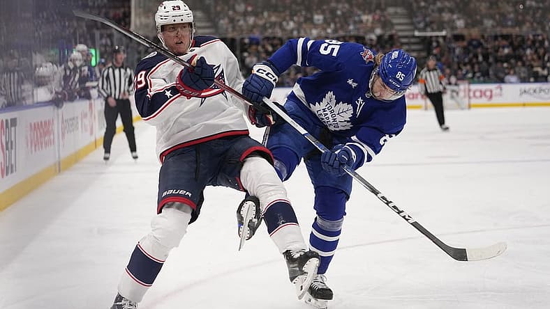 Dec 14, 2023; Toronto, Ontario, CAN; Toronto Maple Leafs defenseman William Lagesson (85) upends Columbus Blue Jackets forward Patrik Laine (29) as they go to the boards during the second period at Scotiabank Arena. Mandatory Credit: John E. Sokolowski-USA TODAY Sports