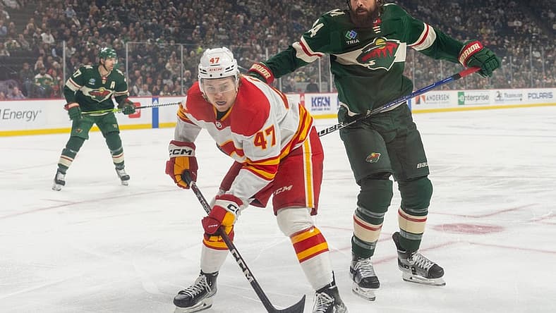 Dec 14, 2023; Saint Paul, Minnesota, USA; Calgary Flames center Connor Zary (47) is challenged by Minnesota Wild defenseman Zach Bogosian (24) in the first period at Xcel Energy Center. Mandatory Credit: Matt Blewett-USA TODAY Sports