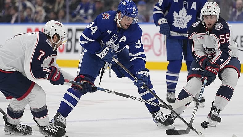 Dec 14, 2023; Toronto, Ontario, CAN; Toronto Maple Leafs forward Auston Matthews (34) battles for th epuck with Columbus Blue Jackets forward Sean Kuraly (7) and Columbus Blue Jackets forward Yegor Chinakhov (59) during the third period at Scotiabank Arena. Mandatory Credit: John E. Sokolowski-USA TODAY Sports