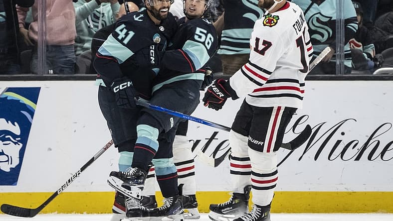 Dec 14, 2023; Seattle, Washington, USA; Seattle Kraken forward Kailer Yamamoto (56) celebrates with forward Pierre-Edouard Bellemare (41) in front of Chicago Blackhawks forward Nick Foligno (17) after scoring a goal during the first period at Climate Pledge Arena. Mandatory Credit: Stephen Brashear-USA TODAY Sports