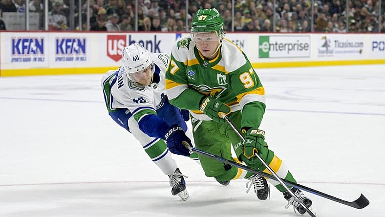 Dec 16, 2023; Saint Paul, Minnesota, USA;  Minnesota Wild forward Kirill Kaprizov (97) controls the puck as Vancouver Canucks forward Elias Pettersson (40) defends during overtime at Xcel Energy Center. Mandatory Credit: Nick Wosika-USA TODAY Sports