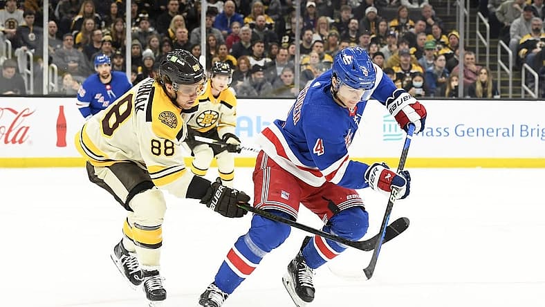 Dec 16, 2023; Boston, Massachusetts, USA;  Boston Bruins right wing David Pastrnak (88) and New York Rangers defenseman Braden Schneider (4) battle for the puck during the first period at TD Garden. Mandatory Credit: Bob DeChiara-USA TODAY Sports