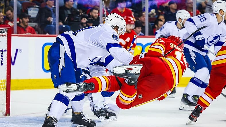 Dec 16, 2023; Calgary, Alberta, CAN; Tampa Bay Lightning defenseman Erik Cernak (81) and Calgary Flames center Yegor Sharangovich (17) battle for the puck during the second period at Scotiabank Saddledome. Mandatory Credit: Sergei Belski-USA TODAY Sports