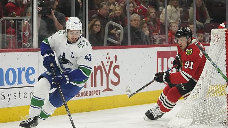 Dec 17, 2023; Chicago, Illinois, USA;   Vancouver Canucks defenseman Quinn Hughes (43) carries the puck chased by Chicago Blackhawks Anthony Beauvillier (91) during the first period at United Center. Mandatory Credit: David Banks-USA TODAY Sports