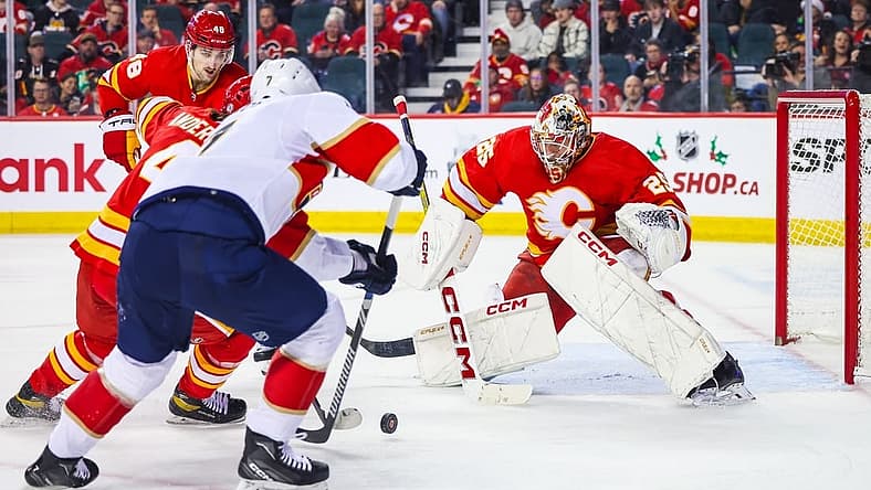 Dec 18, 2023; Calgary, Alberta, CAN; Calgary Flames goaltender Jacob Markstrom (25) makes a save against Florida Panthers defenseman Dmitry Kulikov (7) during the second period at Scotiabank Saddledome. Mandatory Credit: Sergei Belski-USA TODAY Sports