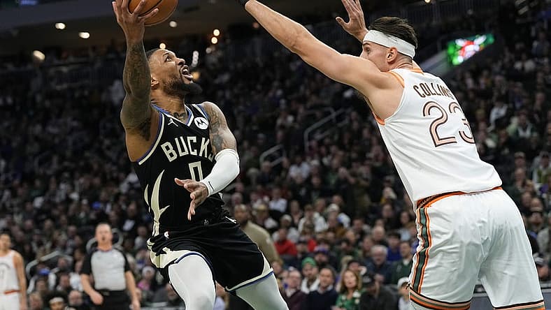 Dec 19, 2023; Milwaukee, Wisconsin, USA; Milwaukee Bucks guard Damian Lillard (0) shoots around San Antonio Spurs center Zach Collins (23) during the first quarter at Fiserv Forum. Mandatory Credit: Jeff Hanisch-USA TODAY Sports