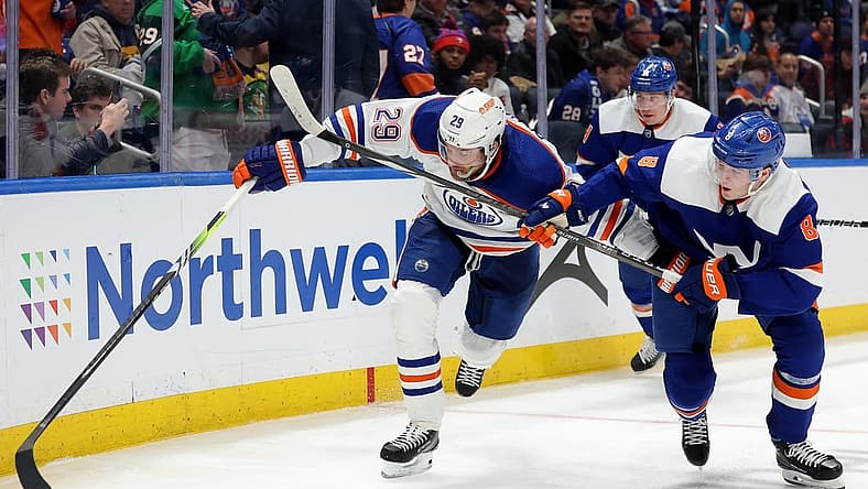 Dec 19, 2023; Elmont, New York, USA; Edmonton Oilers center Leon Draisaitl (29) fights for the puck against New York Islanders defenseman Noah Dobson (8) during the third period at UBS Arena. Mandatory Credit: Brad Penner-USA TODAY Sports