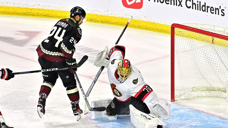 Dec 19, 2023; Tempe, Arizona, USA; Ottawa Senators goaltender Joonas Korpisalo (70) makes a save on Arizona Coyotes defenseman Matt Dumba (24) in the first period at Mullett Arena. Mandatory Credit: Matt Kartozian-USA TODAY Sports