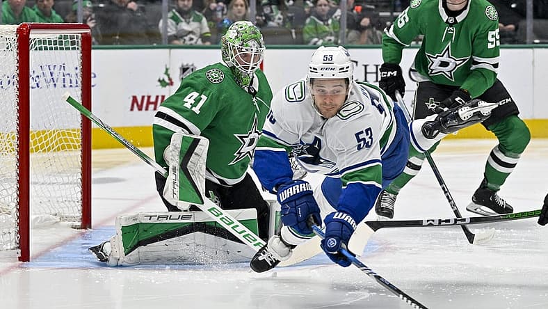 Dec 21, 2023; Dallas, Texas, USA; Vancouver Canucks center Teddy Blueger (53) is tripped up in front of Dallas Stars goaltender Scott Wedgewood (41) as he tires to control the puck during the first period at the American Airlines Center. Mandatory Credit: Jerome Miron-USA TODAY Sports