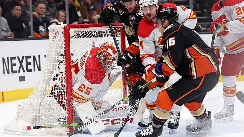 Dec 21, 2023; Anaheim, California, USA; Calgary Flames goaltender Jacob Markstrom (25) defends the goal against Anaheim Ducks center Ryan Strome (16) and right wing Frank Vatrano (77) during the second period at Honda Center. Mandatory Credit: Kiyoshi Mio-USA TODAY Sports