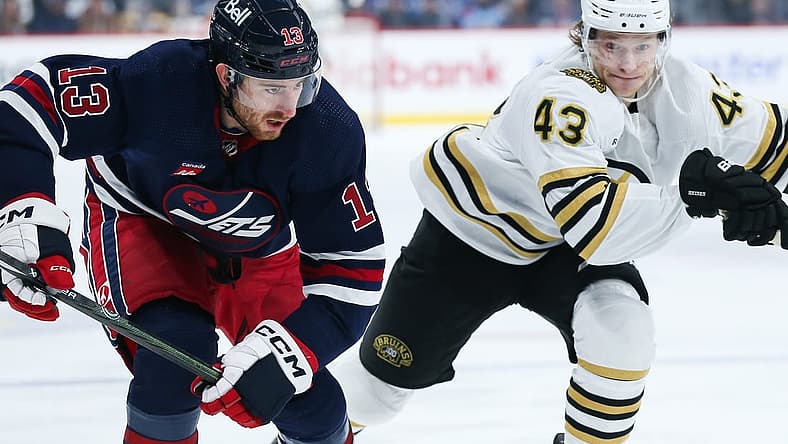 Dec 22, 2023; Winnipeg, Manitoba, CAN;  Winnipeg Jets forward Gabriel Vilardi (13) and Boston Bruins forward Danton Heinen (43) skate after the puck during the first period at Canada Life Centre. Mandatory Credit: Terrence Lee-USA TODAY Sports
