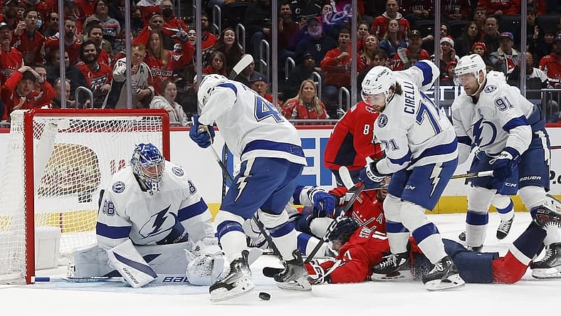 Dec 23, 2023; Washington, District of Columbia, USA; Washington Capitals center Dylan Strome (17) is checked from behind by Tampa Bay Lightning center Steven Stamkos (91) while reaching for the puck in front of Lightning goaltender Andrei Vasilevskiy (88) in the first period at Capital One Arena. Mandatory Credit: Geoff Burke-USA TODAY Sports