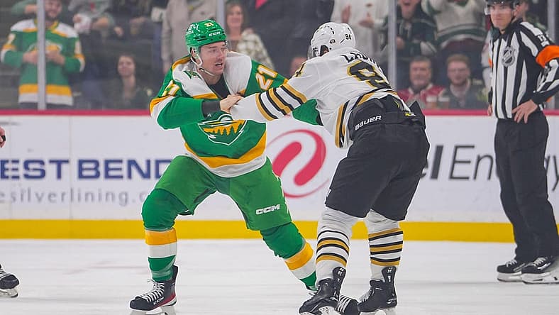 Dec 23, 2023; Saint Paul, Minnesota, USA; Minnesota Wild right wing Brandon Duhaime (21) and Boston Bruins center Jakub Lauko (94) fight  in the first period at Xcel Energy Center. Mandatory Credit: Brad Rempel-USA TODAY Sports
