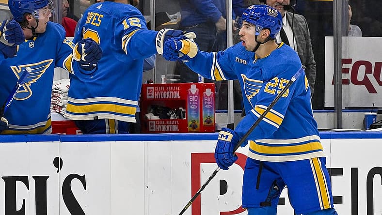 Dec 23, 2023; St. Louis, Missouri, USA; St. Louis Blues center Jordan Kyrou (25) is congratulated by right wing Kevin Hayes (12) and left wing Jake Neighbours (63) after scoring against the Chicago Blackhawks during the third period at Enterprise Center. Mandatory Credit: Jeff Curry-USA TODAY Sports
