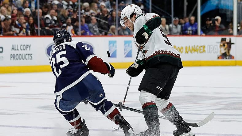 Dec 23, 2023; Denver, Colorado, USA; Colorado Avalanche right wing Logan O'Connor (25) and Arizona Coyotes defenseman Sean Durzi (50) battle for the puck in the third period at Ball Arena. Mandatory Credit: Isaiah J. Downing-USA TODAY Sports