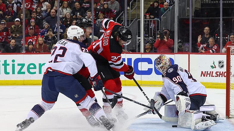 Dec 27, 2023; Newark, New Jersey, USA; Columbus Blue Jackets goaltender Elvis Merzlikins (90) makes a save on New Jersey Devils center Michael McLeod (20) during the second period at Prudential Center. Mandatory Credit: Ed Mulholland-USA TODAY Sports