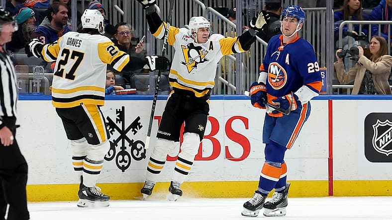 Dec 27, 2023; Elmont, New York, USA; Pittsburgh Penguins center Evgeni Malkin (71) celebrates his goal against the New York Islanders with defenseman Ryan Graves (27) in front of Islanders center Brock Nelson (29) during the second period at UBS Arena. Mandatory Credit: Brad Penner-USA TODAY Sports