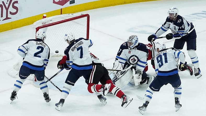 Dec 27, 2023; Chicago, Illinois, USA; Chicago Blackhawks center Connor Bedard (98) scores a goal on Winnipeg Jets goaltender Connor Hellebuyck (37) during the first period at United Center. Mandatory Credit: David Banks-USA TODAY Sports