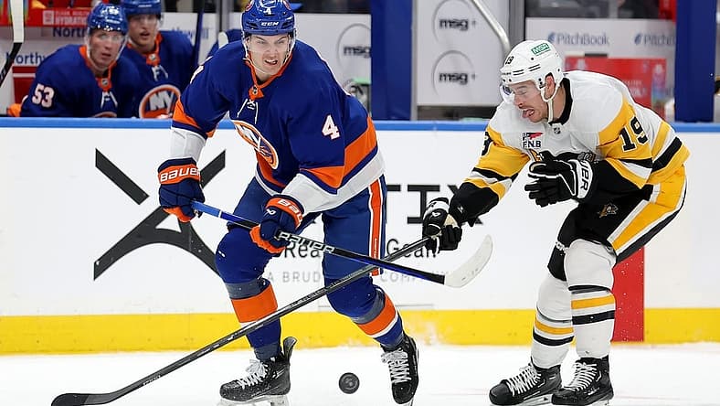 Dec 27, 2023; Elmont, New York, USA; New York Islanders defenseman Samuel Bolduc (4) fights for the puck against Pittsburgh Penguins right wing Reilly Smith (19) during the third period at UBS Arena. Mandatory Credit: Brad Penner-USA TODAY Sports