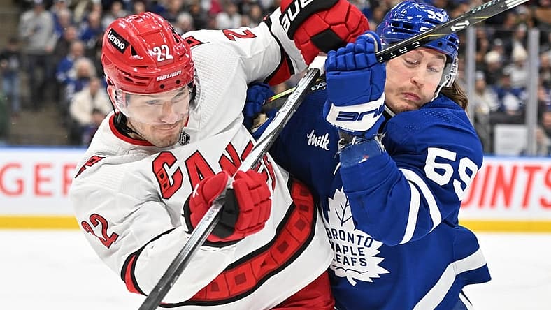 Dec 30, 2023; Toronto, Ontario, CAN; Carolina Hurricanes defenseman Brett Pesce (22) battles for position with Toronto Maple Leafs forward Tyler Bertuzzi (59) in the first period at Scotiabank Arena. Mandatory Credit: Dan Hamilton-USA TODAY Sports