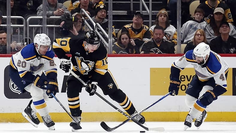 Dec 30, 2023; Pittsburgh, Pennsylvania, USA; Pittsburgh Penguins left wing Drew O'Connor (10) handles the puck against St. Louis Blues left wing Brandon Saad (20) and defenseman Nick Leddy (4) during the second period at PPG Paints Arena. Mandatory Credit: Charles LeClaire-USA TODAY Sports