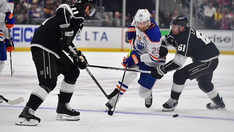Dec 30, 2023; Los Angeles, California, USA; Edmonton Oilers center Leon Draisaitl (29) moves the puck against Los Angeles Kings center Trevor Lewis (61) and center Anze Kopitar (11) during the first period at Crypto.com Arena. Mandatory Credit: Gary A. Vasquez-USA TODAY Sports