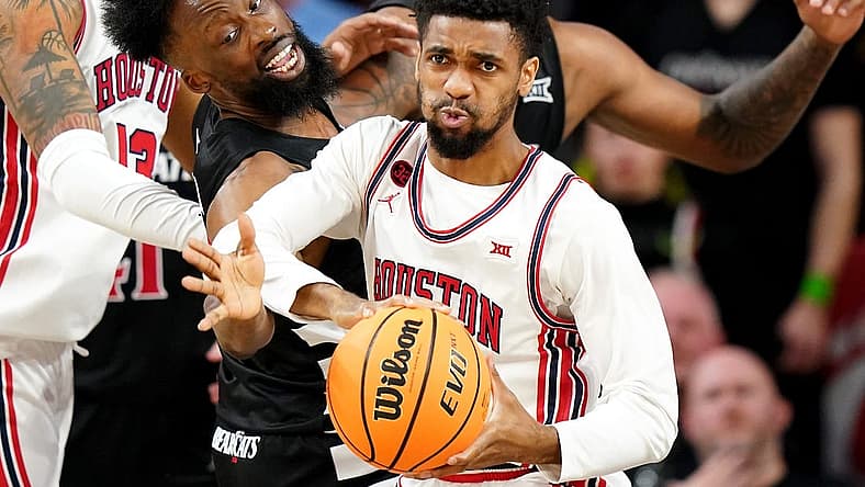 Cincinnati Bearcats forward John Newman III (15) reaches for a rebound against Houston Cougars guard Mylik Wilson (8) in the second half of an NCAA college basketball game between the Houston Cougars and the Cincinnati Bearcats, Saturday, Feb. 10, 2024, at Fifth Third Arena in Cincinnati.