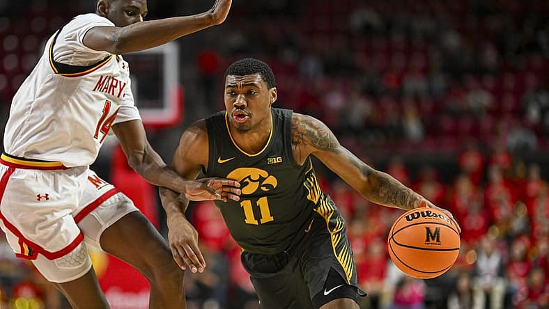 Feb 14, 2024; College Park, Maryland, USA; Iowa Hawkeyes guard Tony Perkins (11) drive to the basket on Maryland Terrapins forward Mady Traore (14) during the fist half at Xfinity Center. Mandatory Credit: Tommy Gilligan-USA TODAY Sports