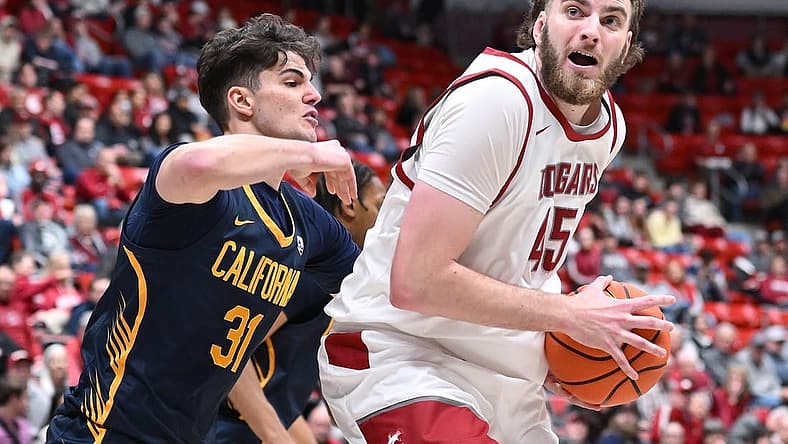 Feb 15, 2024; Pullman, Washington, USA; Washington State Cougars forward Oscar Cluff (45) shoots the ball against California Golden Bears guard Gus Larson (31) in the first half at Friel Court at Beasley Coliseum. Mandatory Credit: James Snook-USA TODAY Sports