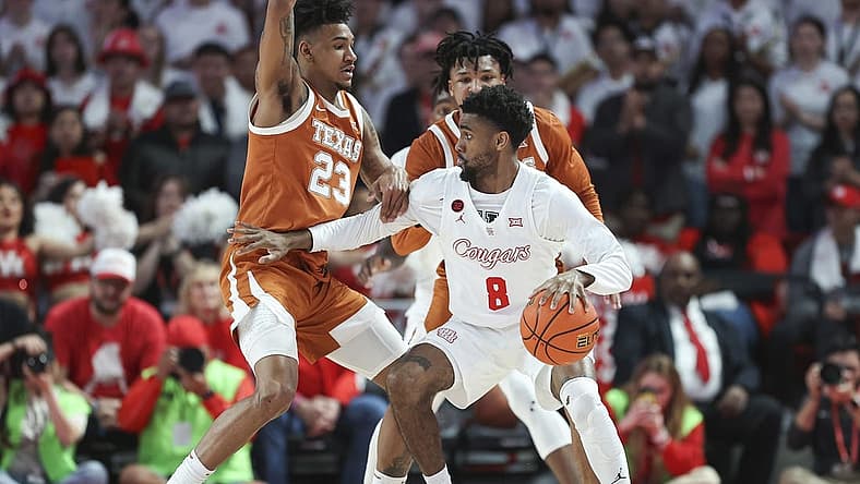 Feb 17, 2024; Houston, Texas, USA; Texas Longhorns forward Dillon Mitchell (23) defends against Houston Cougars guard Mylik Wilson (8) during the first half at Fertitta Center. Mandatory Credit: Troy Taormina-USA TODAY Sports