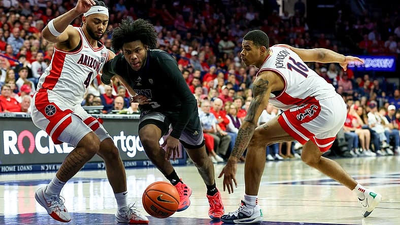 Feb 24, 2024; Tucson, Arizona, USA; Washington Huskies guard Sahvir Wheeler (5) drives to the basket against Arizona Wildcats guard Kylan Boswell (4) and forward Keshad Johnson (16) during the first half at McKale Center. Mandatory Credit: Zachary BonDurant-USA TODAY Sports