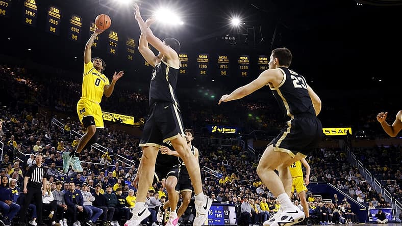 Feb 25, 2024; Ann Arbor, Michigan, USA;  Michigan Wolverines guard Dug McDaniel (0) shoots over Purdue Boilermakers center Zach Edey (15) in the first half at Crisler Center. Mandatory Credit: Rick Osentoski-USA TODAY Sports