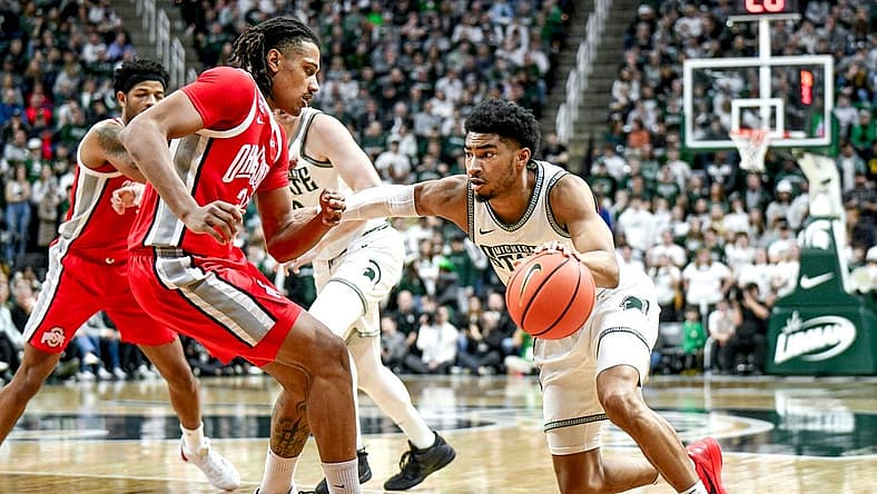 Michigan State's Jaden Akins, right, moves the ball as Ohio State's Devin Royal defends during the first half on Sunday, Feb. 25, 2024, at the Breslin Center in East Lansing.