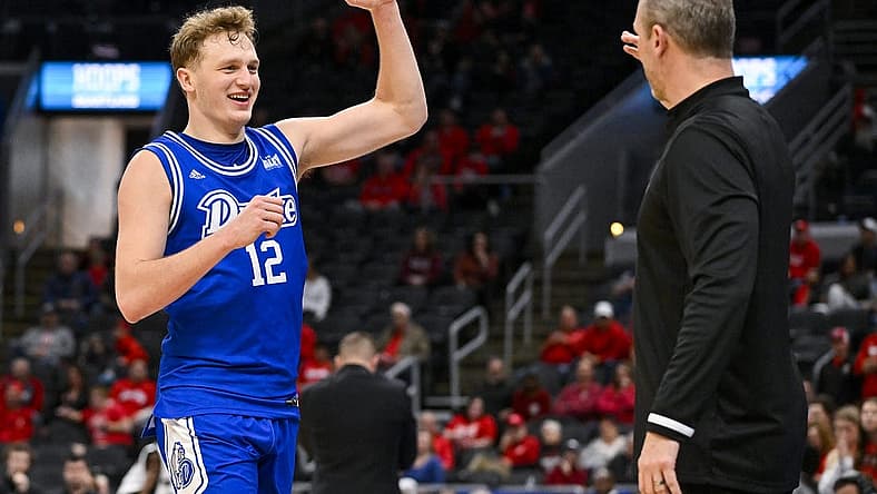 Mar 5, 2023; St. Louis, MO, USA; Drake Bulldogs guard Tucker DeVries (12) celebrates with head coach Darian DeVries during the second half against the Bradley Braves in the finals of the Missouri Valley Conference Tournament at Enterprise Center. Mandatory Credit: Jeff Curry-USA TODAY Sports