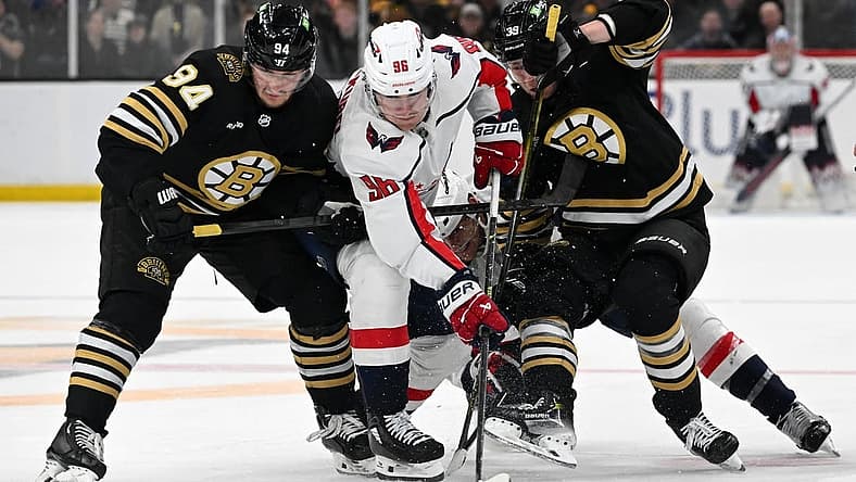 Feb 10, 2024; Boston, Massachusetts, USA; Washington Capitals right wing Nicolas Aube-Kubel (96) battles for the puck against Boston Bruins center Jakub Lauko (94) and center Morgan Geekie (39) during the second period at the TD Garden. Mandatory Credit: Brian Fluharty-USA TODAY Sports