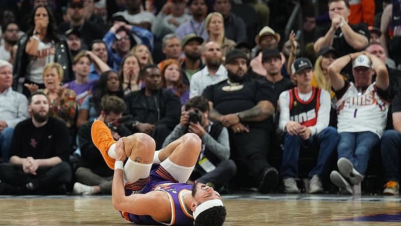 Mar 2, 2024; Phoenix, Arizona, USA; Phoenix Suns guard Devin Booker (1) reacts after being inured against the Houston Rockets during the second half at Footprint Center. Mandatory Credit: Joe Camporeale-USA TODAY Sports