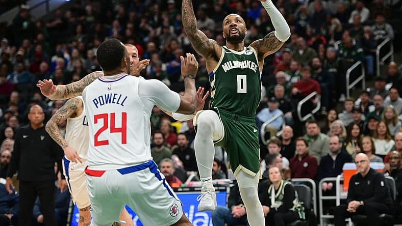 Mar 4, 2024; Milwaukee, Wisconsin, USA; Milwaukee Bucks guard Damian Lillard (0) takes a shot against Los Angeles Clippers guard Norman Powell (24) in the third quarter at Fiserv Forum. Mandatory Credit: Benny Sieu-USA TODAY Sports